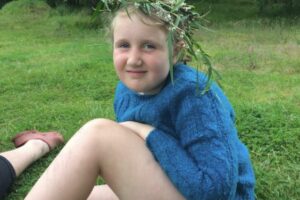 Lola says: "In November, we had an overnight camp with KCC at Wiritoa Lake. We had a fire and toasted marshmallows. There was a swing going over the lake as well as three other playground swings. Here I am wearing a wreath I made at camp."